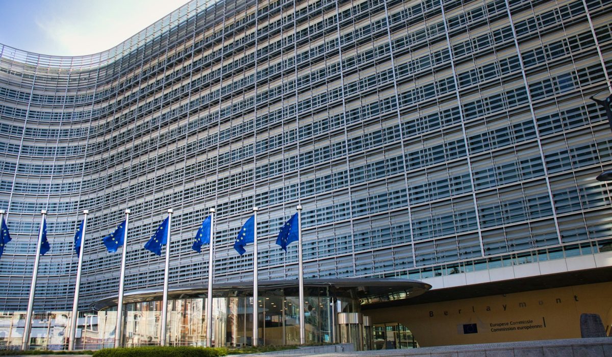 Europaflaggen vor modernem Glasgebäude – EU-Gipfel: Selenskyj fordert 70 Milliarden Euro, Einigung zur Ukraine-Hilfe offen
