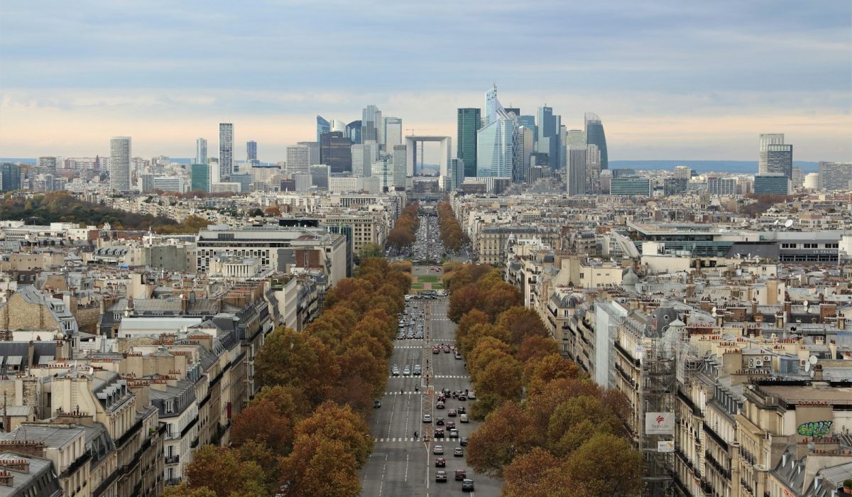 Blick über Paris mit herbstlicher Allee auf das Finanzviertel La Défense – Moody's bestätigt Frankreichs Note Aa3
