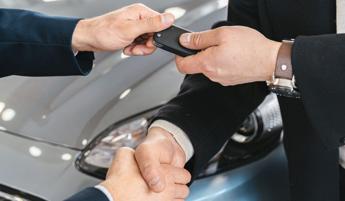 Händedruck bei der Schlüsselübergabe eines finanzierten Autos – Autokredit Berlin 2026