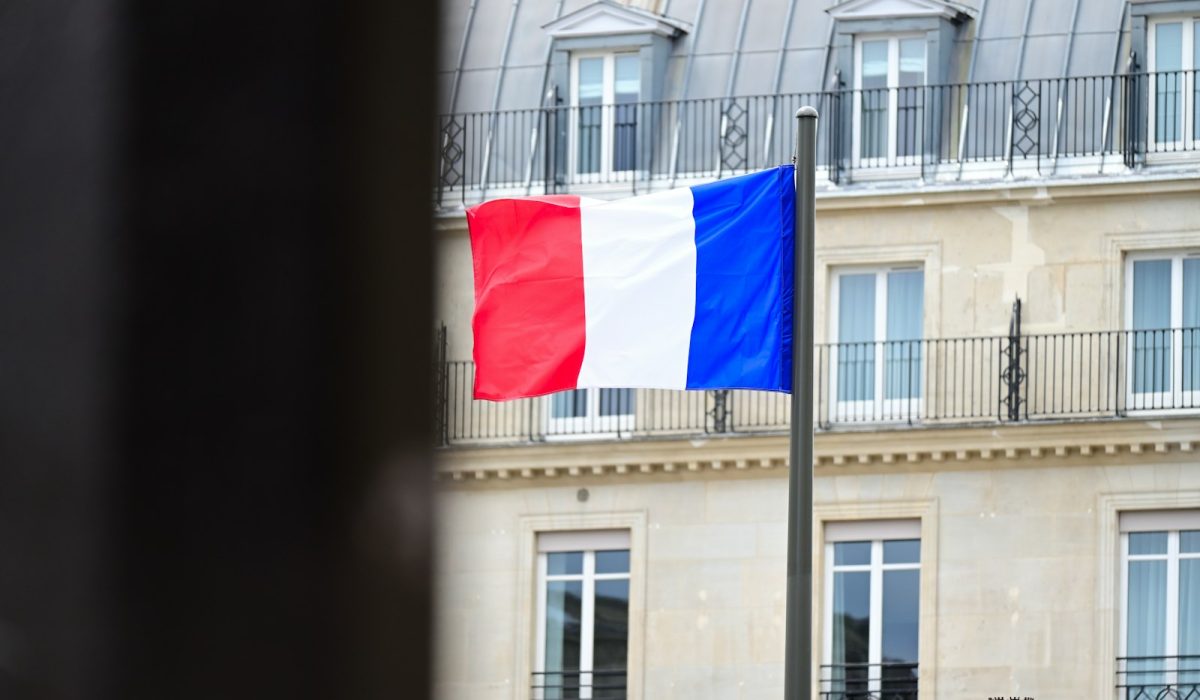 Französische Flagge vor einem Hochhaus – Nach Krawallen in Frankreich steigen Anleiherenditen