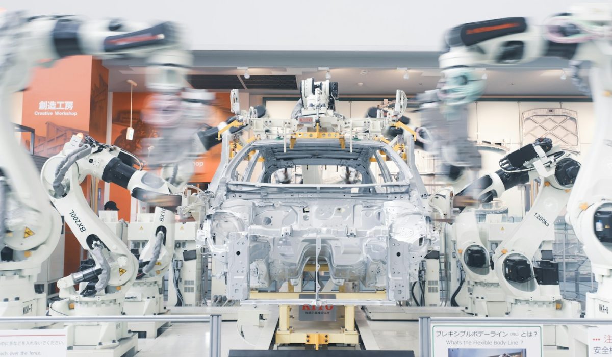 Roboterarme montieren ein Fahrzeug-Chassis in einer Autofabrik – Berlin und Paris einigen sich auf Auto-Paket zum Verbrenner nach 2035